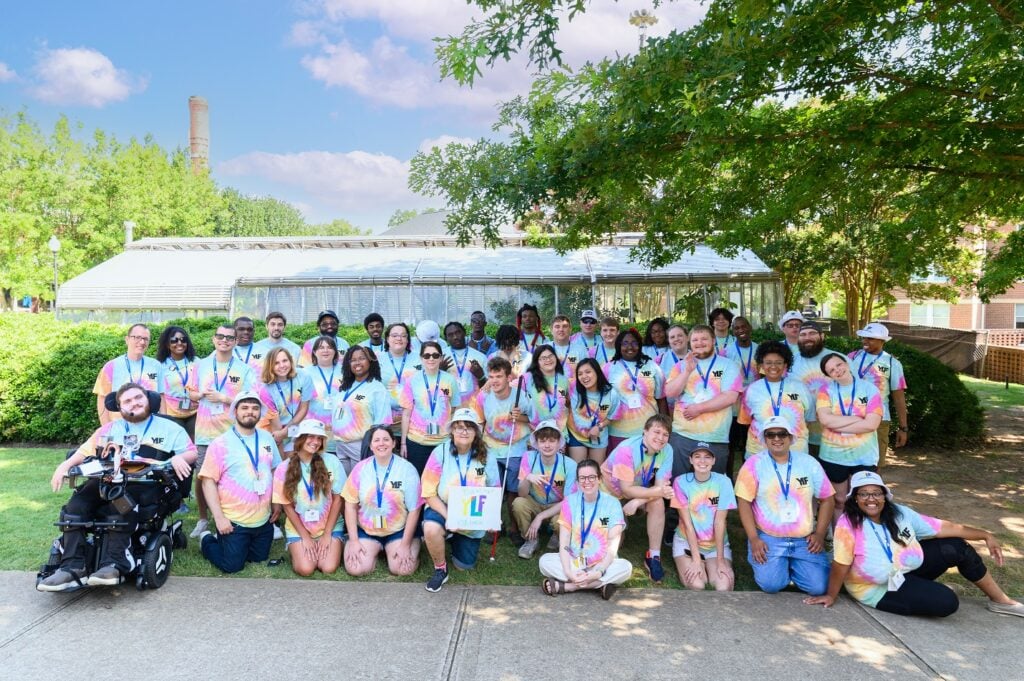 A large group of youth with disabilities and staff outside in matching tie dye shirts at the 2023 SCYLF event.