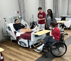 student nurses with disabilities work in a nursing simulation classroom.
